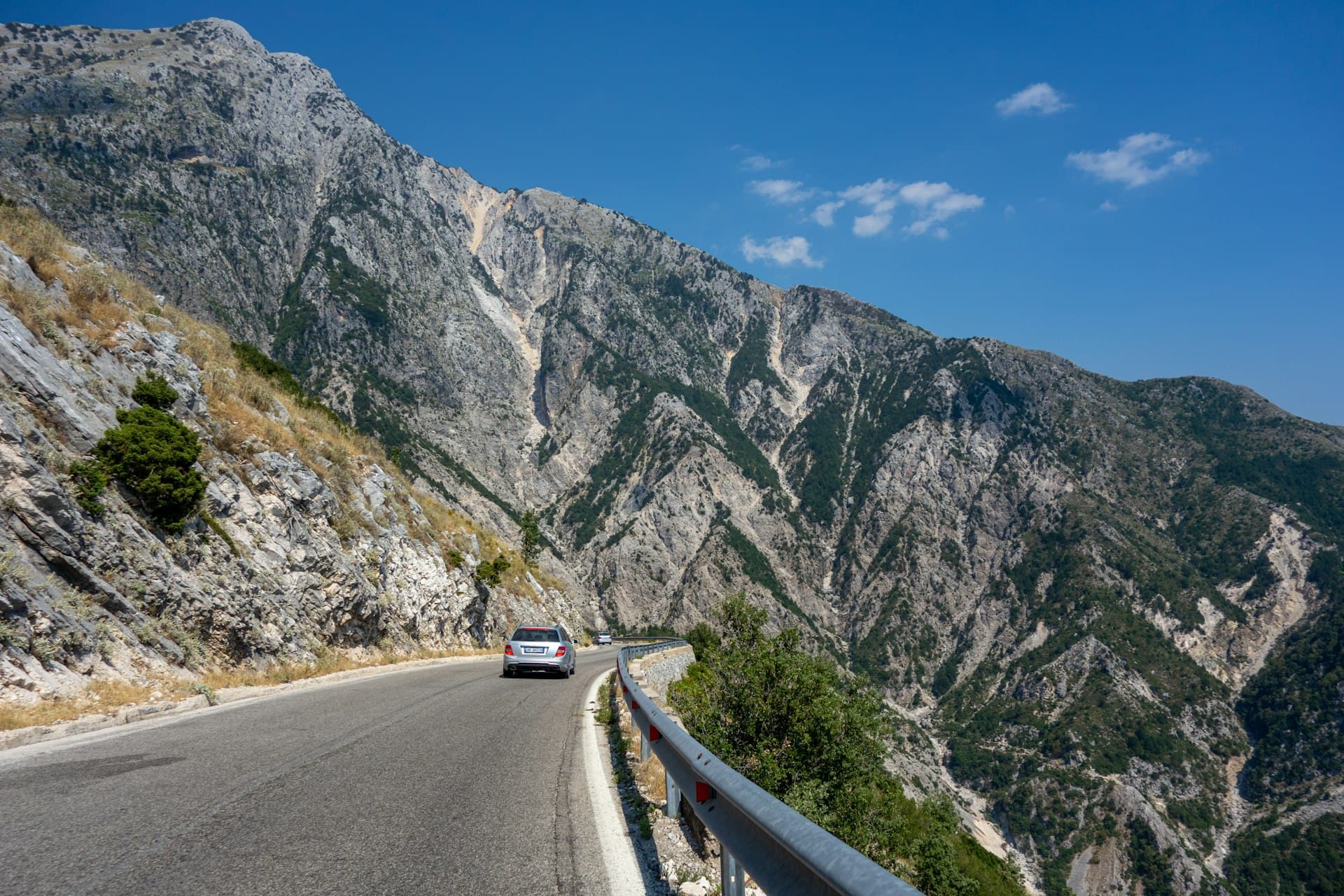 A car on a paved Albanian coastal road